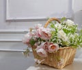 A basket of decorative flowers on a white table