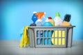 Basket with different cleaning products and supplies on light table Royalty Free Stock Photo