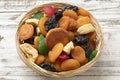 Basket with dried fruit, tutti frutti, on wooden background