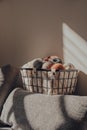 Basket of earth coloured skeins of yarn inside an apartment, sunlight, selective focus Royalty Free Stock Photo
