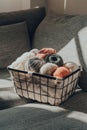 Basket of earth coloured skeins of yarn on a sofa, cool tones, selective focus Royalty Free Stock Photo