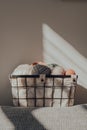 Basket with earth coloured yarn inside an apartment, against a wall, sunlight, selective focus Royalty Free Stock Photo