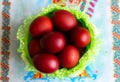 Basket with easter cake and red eggs on rustic wooden table. Top view. Royalty Free Stock Photo