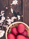 Basket with easter cake and red eggs on rustic wooden table. Top Royalty Free Stock Photo