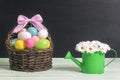 Basket with Easter eggs and a daisy bouquet Royalty Free Stock Photo