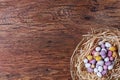 Basket of Easter eggs on a straw bed wood  background with copy space Royalty Free Stock Photo