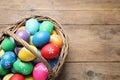 Basket with Easter eggs on wooden table. Space for text Royalty Free Stock Photo