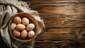 Basket of eggs sits on a wooden table. Royalty Free Stock Photo