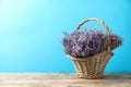 Basket with fresh lavender flowers on wooden table against blue background. Space for Royalty Free Stock Photo