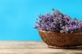 Basket with fresh lavender flowers on wooden  against blue background. Space for text Royalty Free Stock Photo