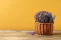 Basket with fresh lavender flowers on wooden table against yellow background. Space for Royalty Free Stock Photo