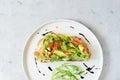 Basket with fresh organic greens, avocado and lime on a dark green background. Monochrome. Royalty Free Stock Photo