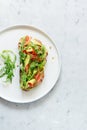 Basket with fresh organic greens, avocado and lime on a dark green background. Monochrome. Royalty Free Stock Photo