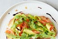 Basket with fresh organic greens, avocado and lime on a dark green background. Monochrome. Royalty Free Stock Photo