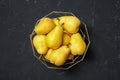 Basket with fresh ripe pears on dark background