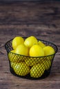 Basket of fresh yellow lemons on a rustic wood table Royalty Free Stock Photo
