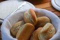 Basket of freshly baked dinner rolls with tableware in background. Macro Royalty Free Stock Photo