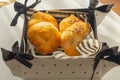 Basket of freshly baked dinner rolls with tableware in background. Macro with shallow dof Royalty Free Stock Photo