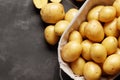 Basket full of fresh, young potatoes board, towel and knife on gray background, Royalty Free Stock Photo