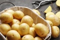 Basket full of fresh, young potatoes board, towel and knife on gray background Royalty Free Stock Photo