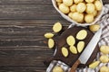 Basket full of fresh, young potatoes board, towel and knife on wooden background, Royalty Free Stock Photo