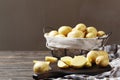 Basket full of fresh, young potatoes board, towel and knife on wooden background Royalty Free Stock Photo