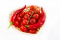 Basket full of tomatoes red bright juicy on a branch with chili peppers on a white background Royalty Free Stock Photo