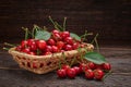 Basket with a harvest of ripe cherries on wooden table Royalty Free Stock Photo