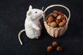 Basket Hazelnuts, white mouse toy on wooden backdrop. heap or stack of hazelnuts
