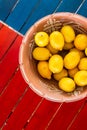 Clay pot basket of lemons on the coloful table with copyspace Royalty Free Stock Photo