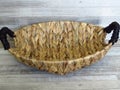 Basket made of Calamus growing in the water. Beautiful Handmade Woven Bamboo / Cane Basket on bleached oak background.