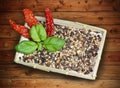 Basket with mixed hot pepper spices, basil and dried chillies Royalty Free Stock Photo