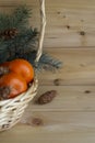 Basket with oranges, apples, Christmas tree warm background. Christmas and new year