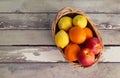 Basket with oranges, nectarines and lemons on aged wooden background Royalty Free Stock Photo