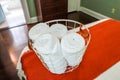 A basket of organized clean rolled white towels for guests sitting on a bed in a guest bedroom Royalty Free Stock Photo