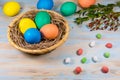 Easter eggs in a wooden basket, painted in different color on a blue background with a place for the inscription next to Royalty Free Stock Photo