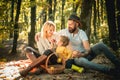 Basket with picnic meal and toys for the kid. Happy family of three lying in the grass in autumn. The concept of a happy Royalty Free Stock Photo