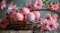 The basket with pink Easter eggs and flowers on wooden table Royalty Free Stock Photo