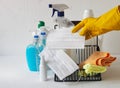 A basket with plastic bottles with detergents and disinfectants on a light background for cleaning and disinfecting at home.A