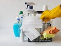 A basket with plastic bottles with detergents and disinfectants on a light background for cleaning and disinfecting at home.A