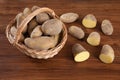 Basket with potatoes, halfed on wood Royalty Free Stock Photo