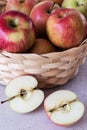 A basket with red apples on a wooden background. Sliced apples Royalty Free Stock Photo