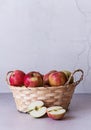 A basket with red apples on a wooden background. Sliced apples Royalty Free Stock Photo