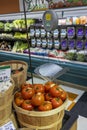 A basket of red tomatoes and a gray metal scale surrounded by groceries at a market in Atlanta Georgia