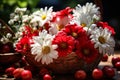 Basket of red and white flowers sits on a table with a bowl of cherries Royalty Free Stock Photo