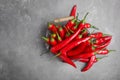Basket with ripe chili peppers on grey background, Royalty Free Stock Photo