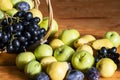 Basket with ripe fruits: apples, pears, grapes, plums selective focus Royalty Free Stock Photo