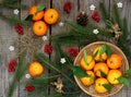 Basket of ripe mandarins, spruce branches and christmas toy on a wooden background. selective focus. Royalty Free Stock Photo