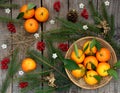 Basket of ripe mandarins, spruce branches and christmas toy on a wooden background. selective focus. Royalty Free Stock Photo