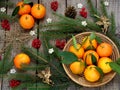 Basket of ripe mandarins, spruce branches and christmas toy on a wooden background. selective focus. Royalty Free Stock Photo